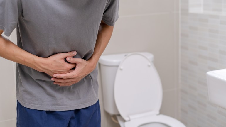 man standing has diarrhea and severely toxic food. Man touch belly in the bathroom. Abdominal pain, Diarrhea, Colon cancer concept ; Shutterstock ID 2168023119; purchase_order: ajnet; job: ; client: ; other: