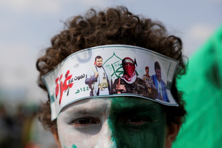 A Houthi supporter with a headband featuring photos of Houthi leader, Abdul-Malik al-Houthi, and spokesman for the Hamas military wing, Abu Ubaidah, attends a rally to mark the anniversary of the birth of the Prophet Mohammad and to show solidarity with Palestinians in the Gaza Strip, in Sanaa, Yemen, September 15, 2024. REUTERS/Khaled Abdullah