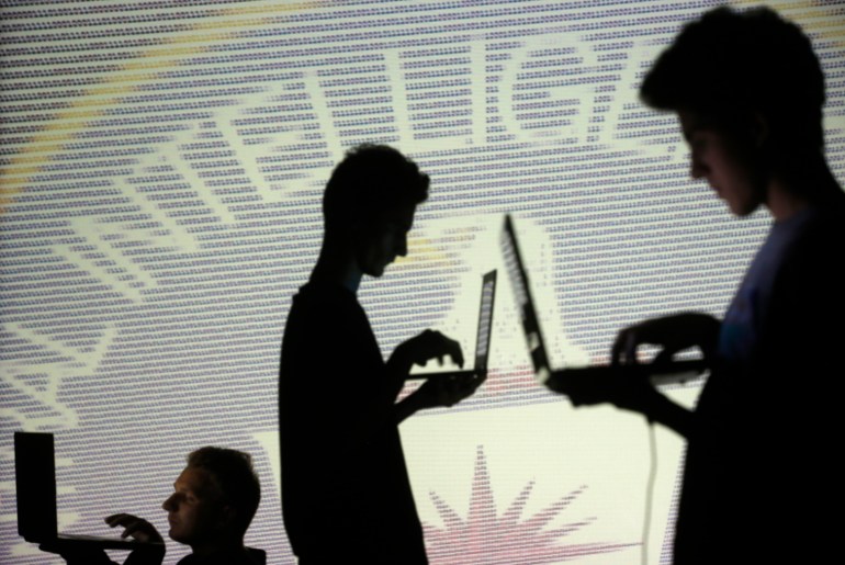 People are silhouetted as they pose with laptops in front of a screen projected with binary code and a Central Inteligence Agency (CIA) emblem, in this picture illustration taken in Zenica October 29, 2014. REUTERS/Dado Ruvic (BOSNIA AND HERZEGOVINA - Tags: BUSINESS SCIENCE TECHNOLOGY BUSINESS LOGO)