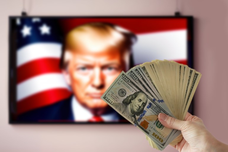 Washington, USA - September 16 2024: hand holding pile of money cash on Donald Trump portrait on TV background. US election 2024.